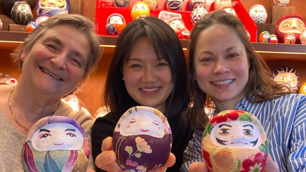 Guests holding the fabric-covered daruma they made at a workshop in Tokyo