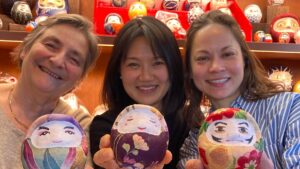 Guests holding the fabric-covered daruma they made at a workshop in Tokyo