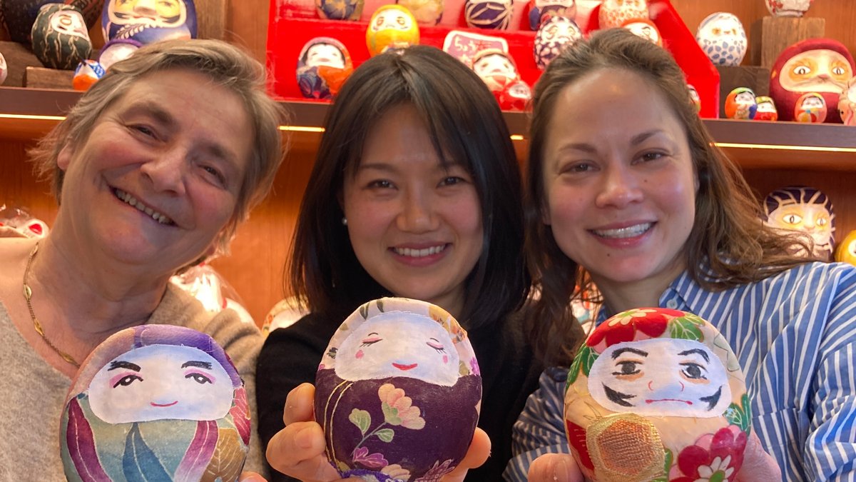 Guests holding the fabric-covered daruma they made at a workshop in Tokyo